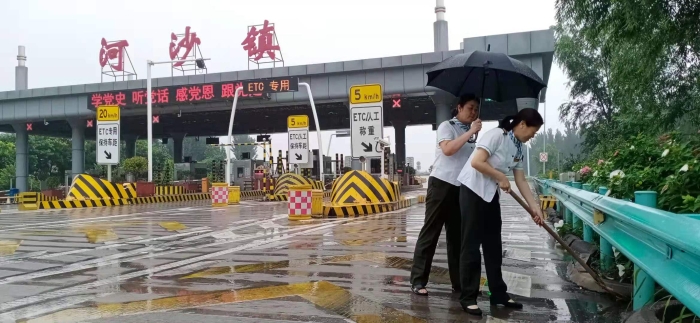 值班站长姜艳红清理排水通道，摄影李亚娟
